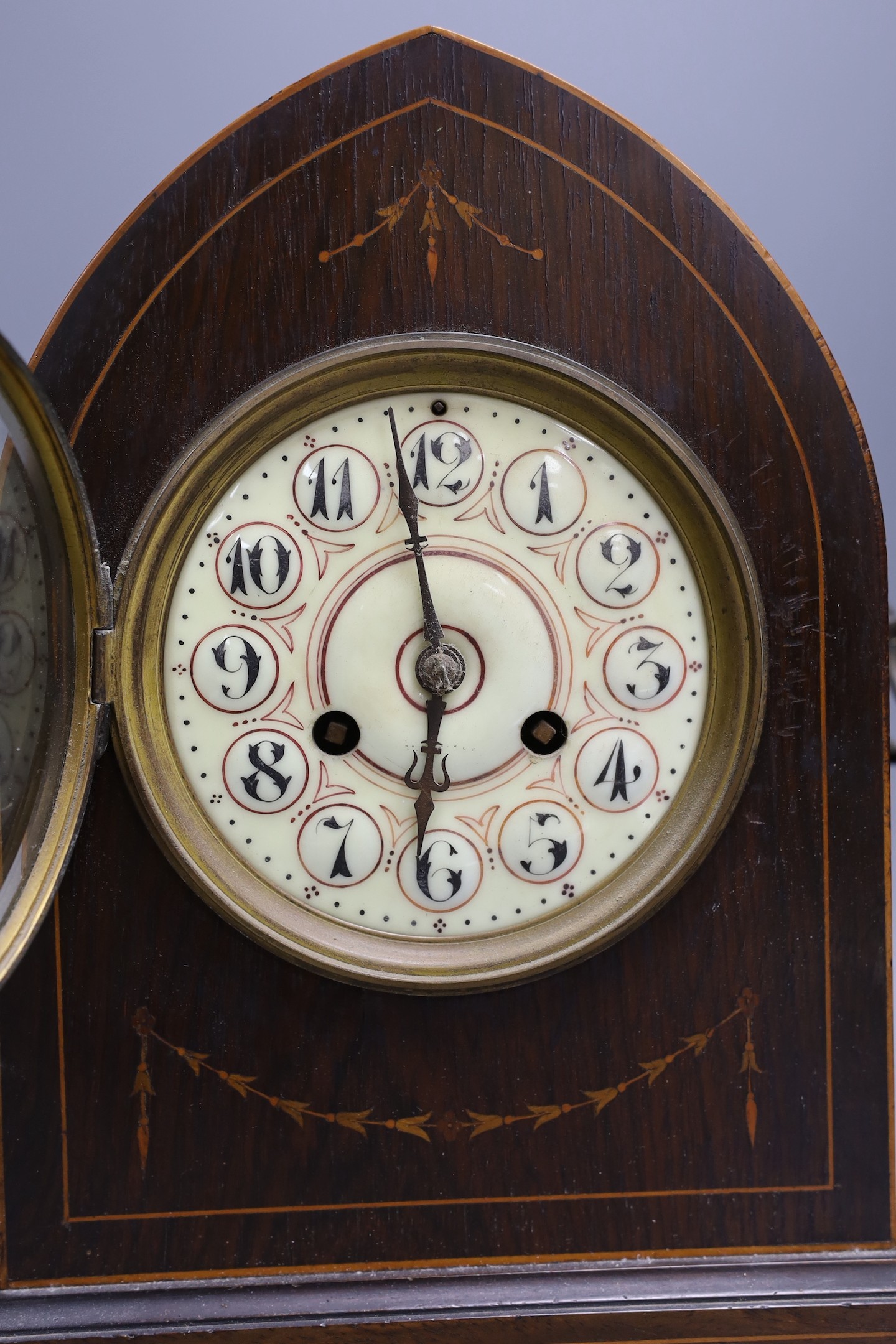 An early 20th century mahogany inlaid dome topped mantel clock, 30 cms high.